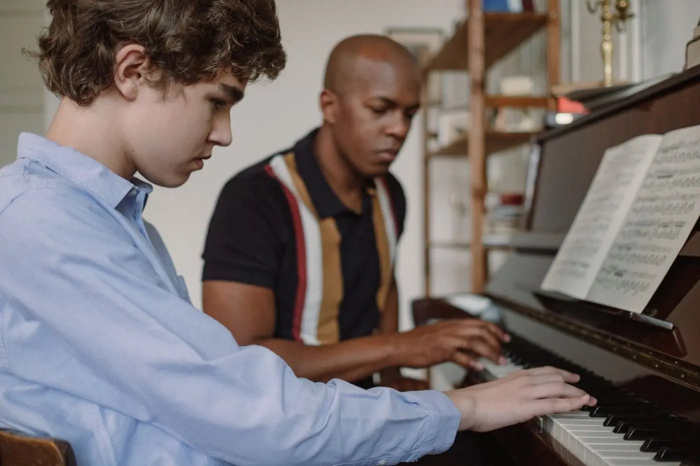 Adolescent apprenant le piano avec son professeur